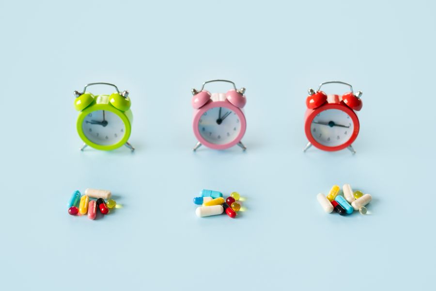  trzy kolorowe zegarki przed każdym leży garść suplementów Blog Zdrowe Dębniki
