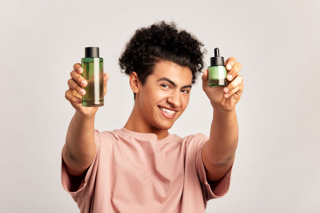 Chłopak z dwoma butlkami olejku konopnego w dłoniach Blog Zdrowe Dębniki